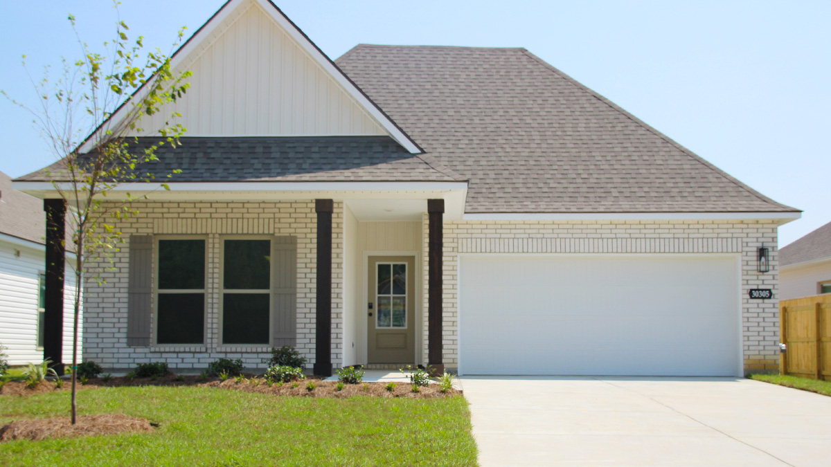 Single-story home with white brick. Cream glass front door with cream shutters and white trim.