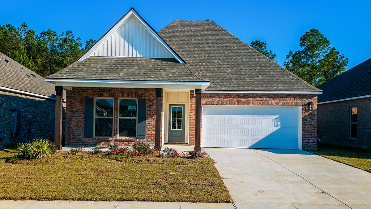 single-story home with red brick and white vinyl siding with black front door and shutters with porch and two-car garage
