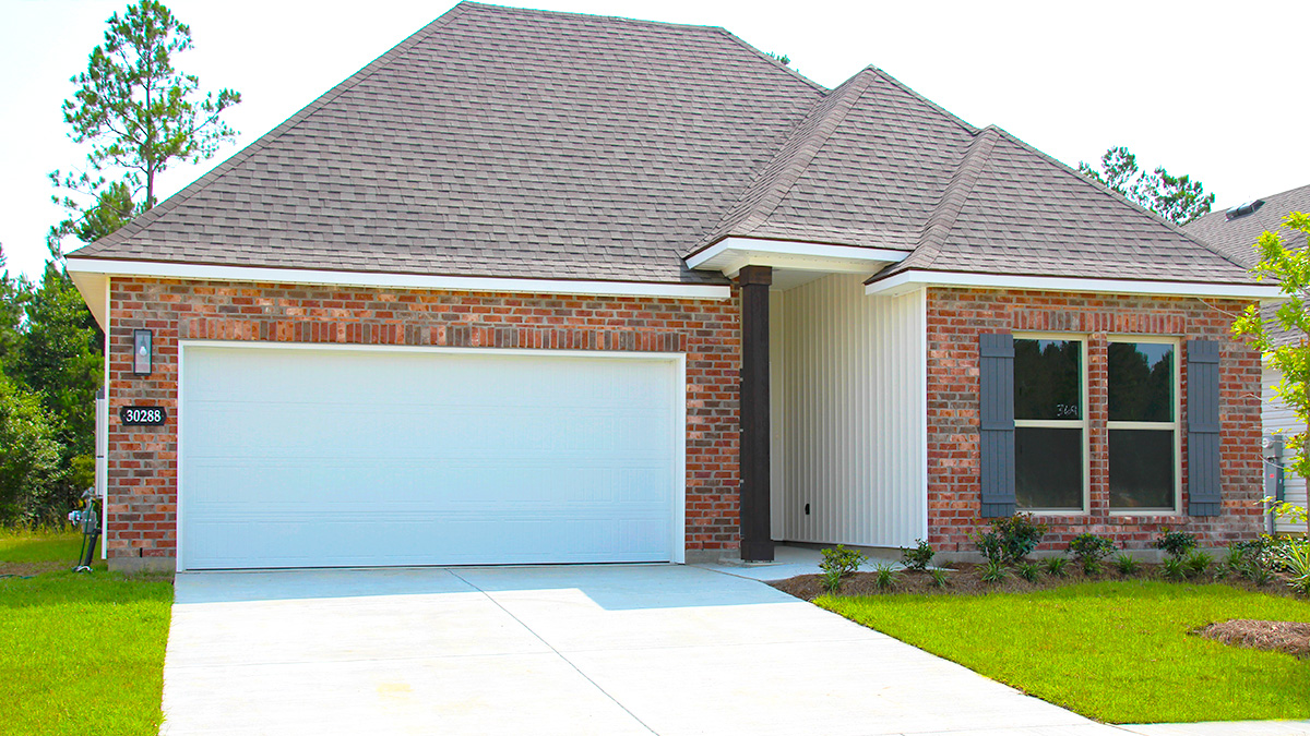 Single-story home with red brick. Blue glass front door with blue shutters and white two car garage.