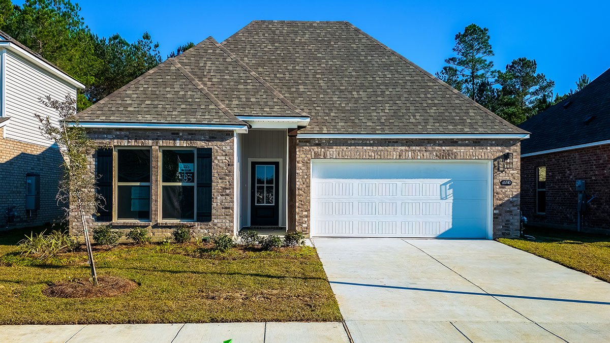 single-story home with gray brick and black front door and shutters with two-car garage