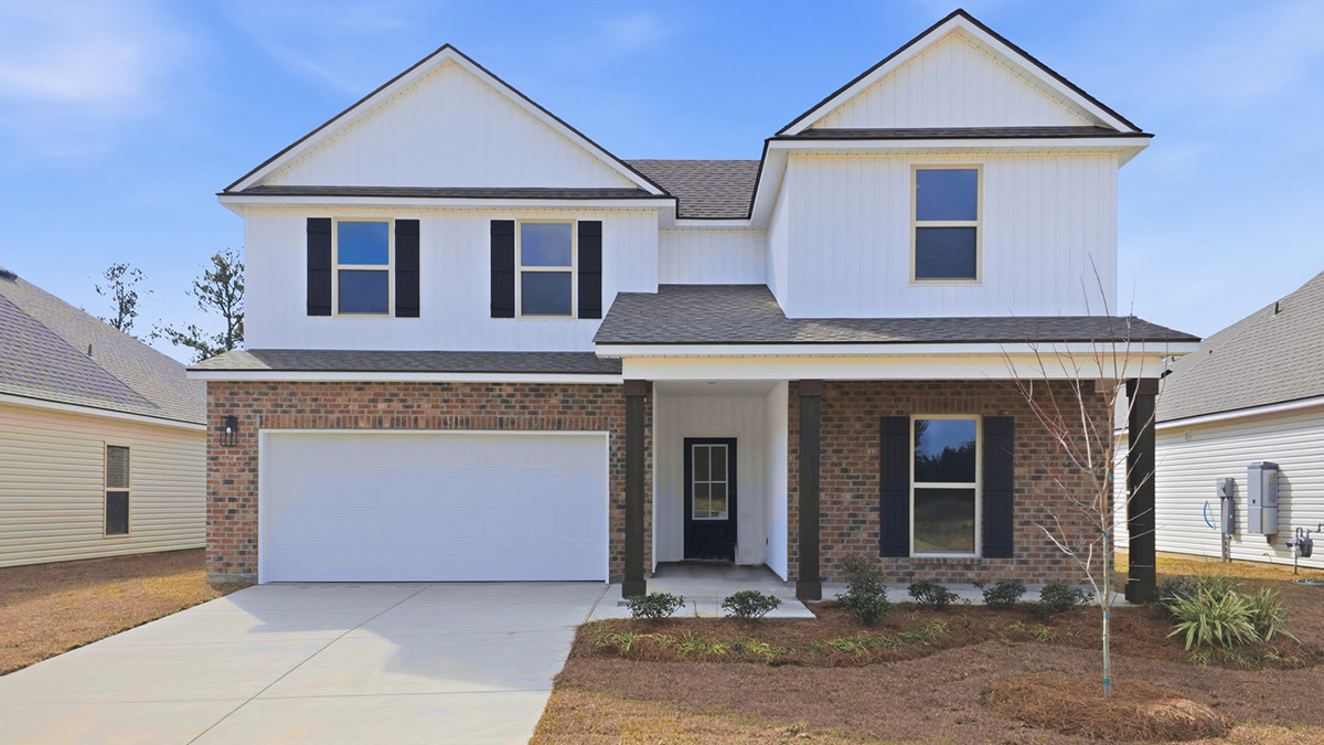 double-story home with red brick and white vinyl siding with black front door and shutters with porch and two-car garage