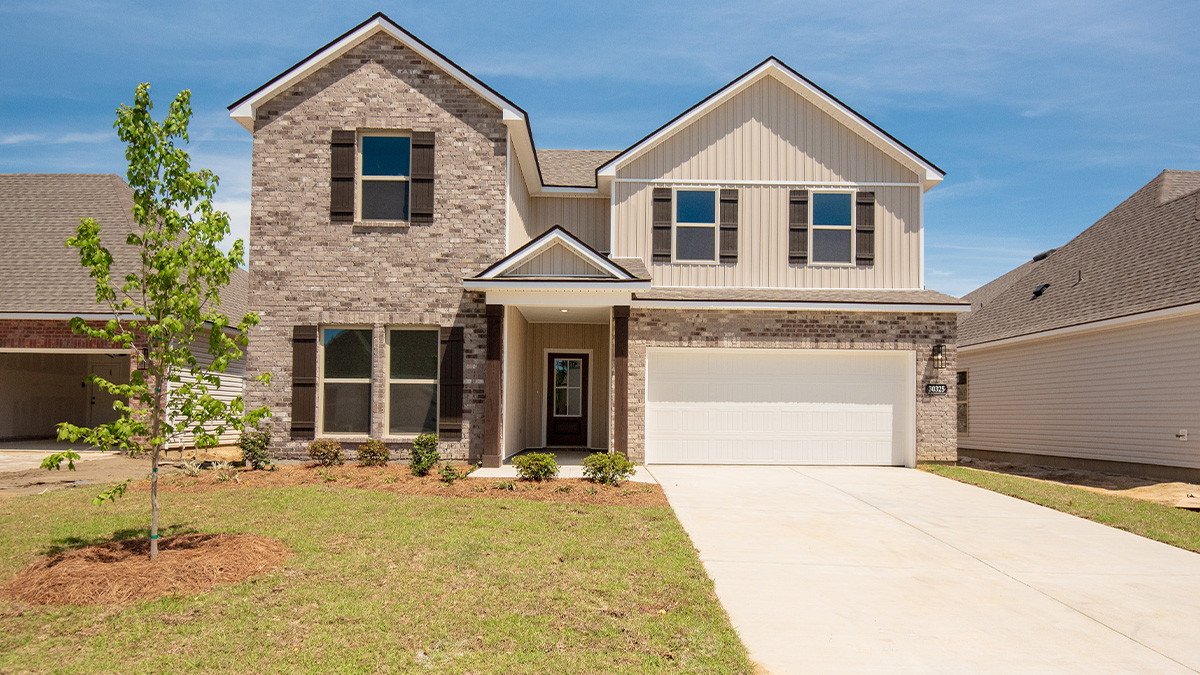 double-story home with tan brick and tan vinyl siding with brown front door and shutters with two-car garage