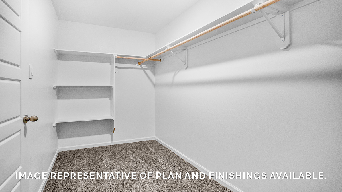 Spacious walk in closet with racks and shelving