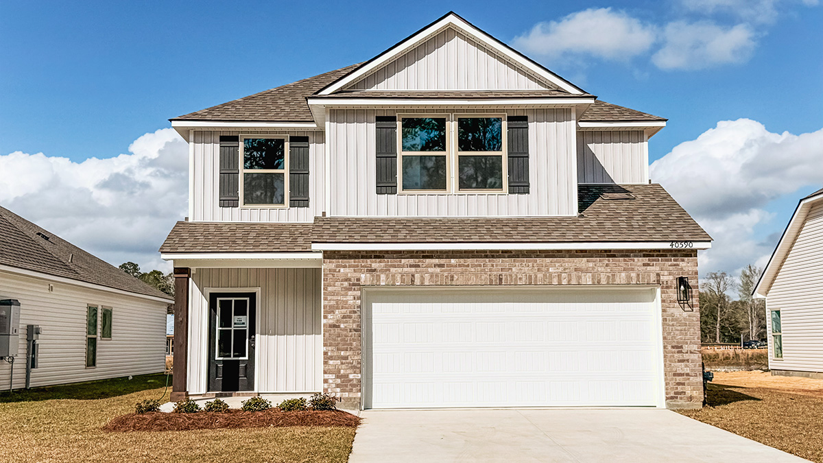 two-story home with gray brick and light gray vinyl siding with black front door and shutters with two-car garage
