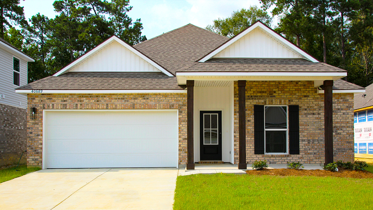 Single-story home with brown brick and white hardie vinyl. Black glass front door with black shutters and white two car garage.