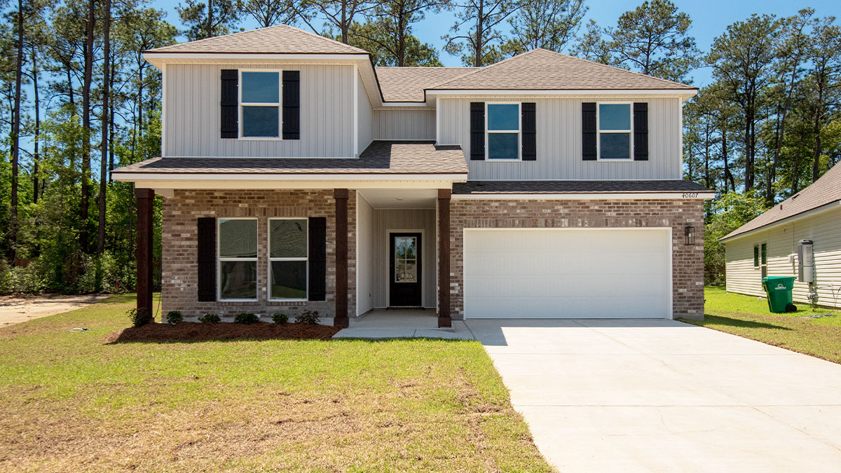 double-story home with grey brick and grey vinyl siding with black front door and shutters with porch and two-car garage