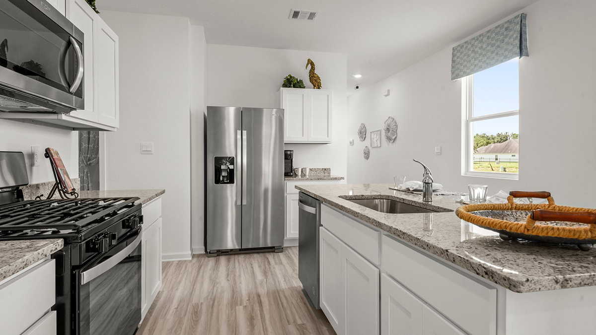 white kitchen island with stainless steel appliances