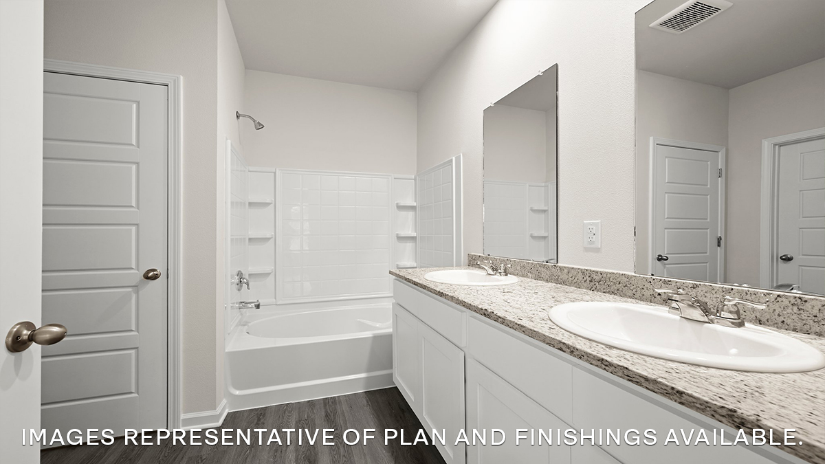 primary bathroom with dual vanities, mirror and shower tub combo