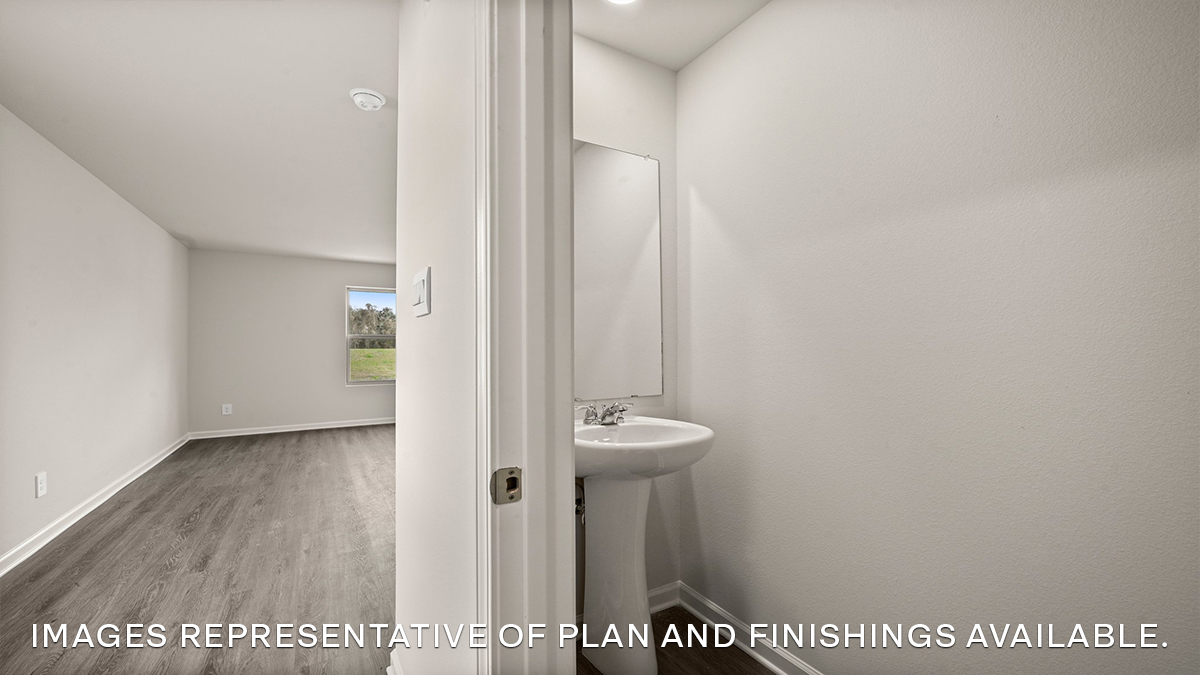 half bathroom in front of the home with pedestal sink and toilet