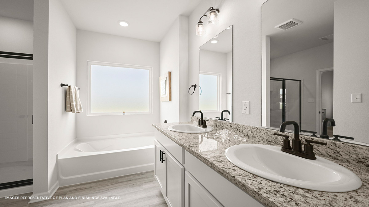 White dual vanities with garden tub in primary bathroom
