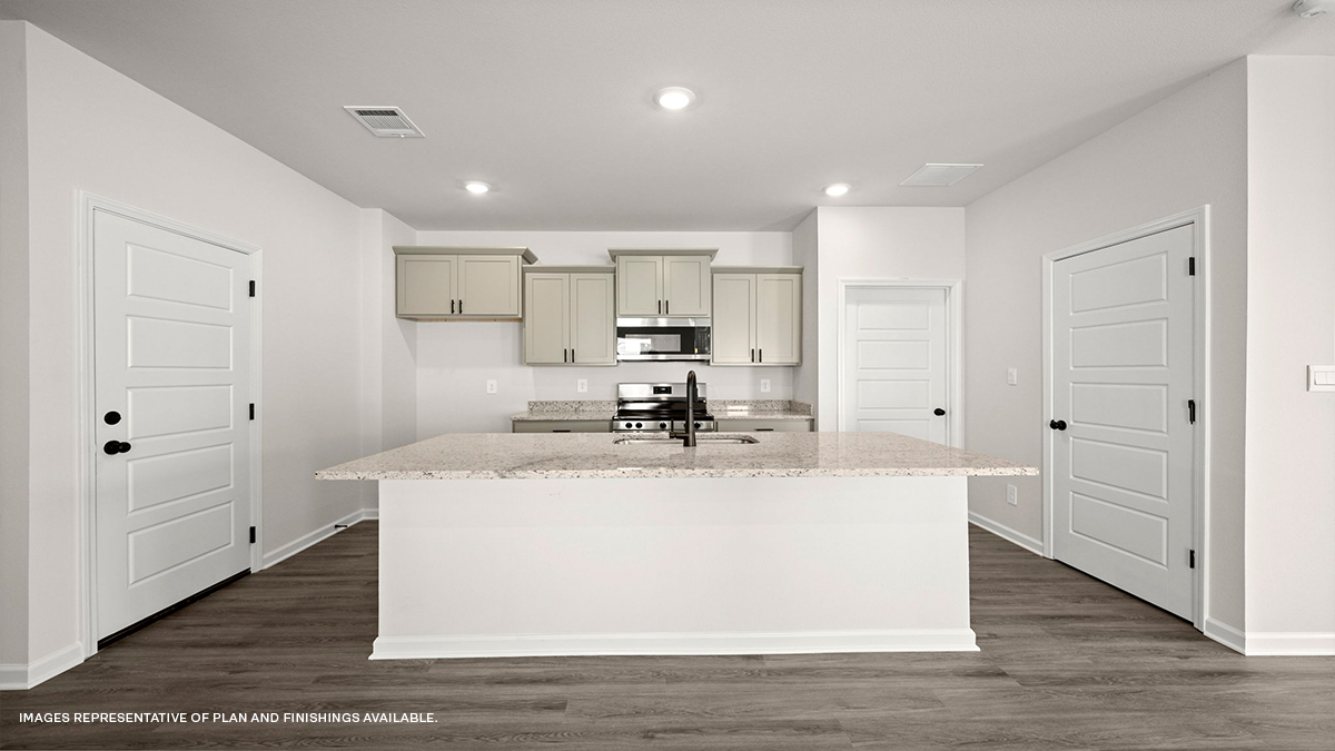 Tan kitchen cabinets with kitchen island and stainless-steel appliances