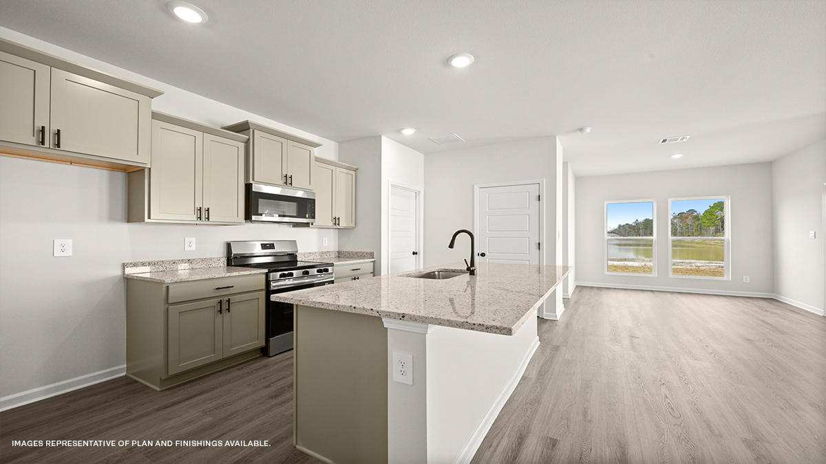 Tan kitchen cabinets with kitchen island and stainless-steel appliances