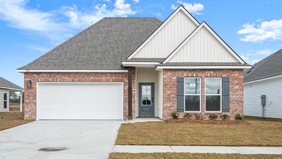single-story home with red brick and tan vinyl siding with gray front door and shutters with two-car garage