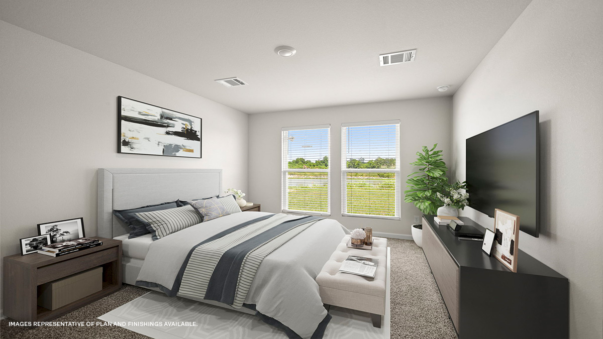Large primary bedroom with dual windows overlooking the backyard