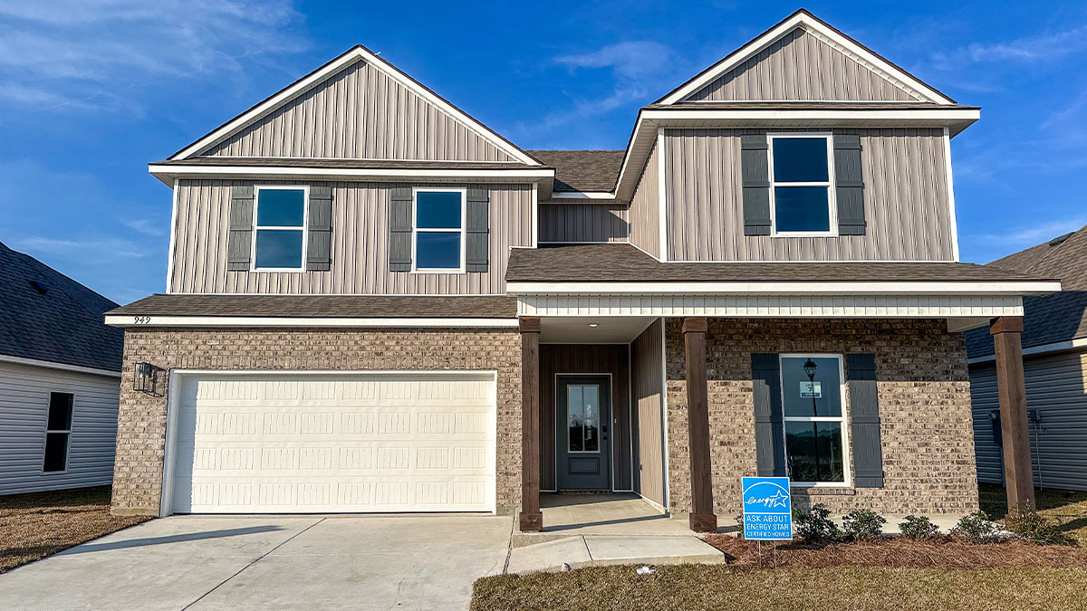 double-story home with tan brick and light gray vinyl siding with gray front door and shutters with porch and two-car garage