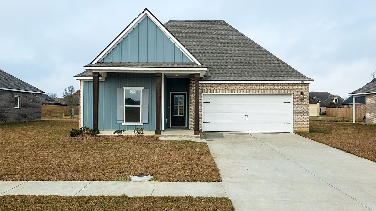single-story home with blue hardie vinyl with tan brick and blur front door and light shutters with porch and two-car garage