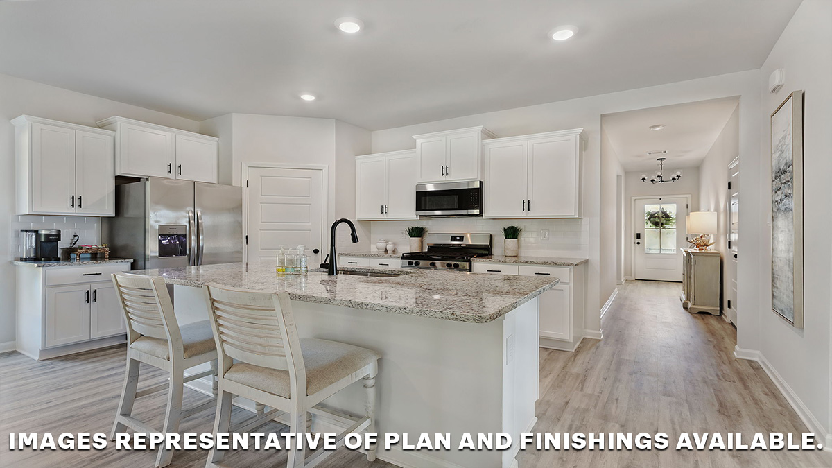 White kitchen island with stainless steel appliances and pantry access