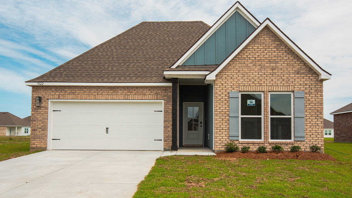 single-story home with tan brick and blue hardi siding with two-car garage