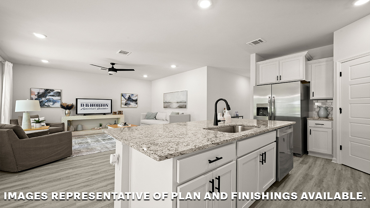 white kitchen island with pantry and stainless-steel appliances with open-concept living room in the rear