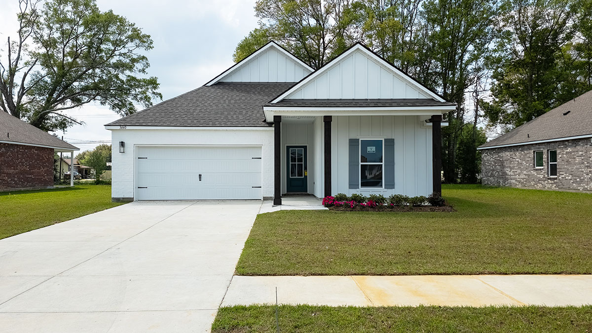 single-story home with white hardie vinyl and gray front door and shutters with two-car garage