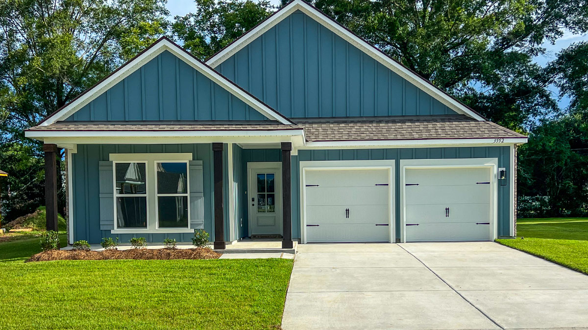 single-story home with blue hardie siding and light blue front door and shutters with porch and two-car garage