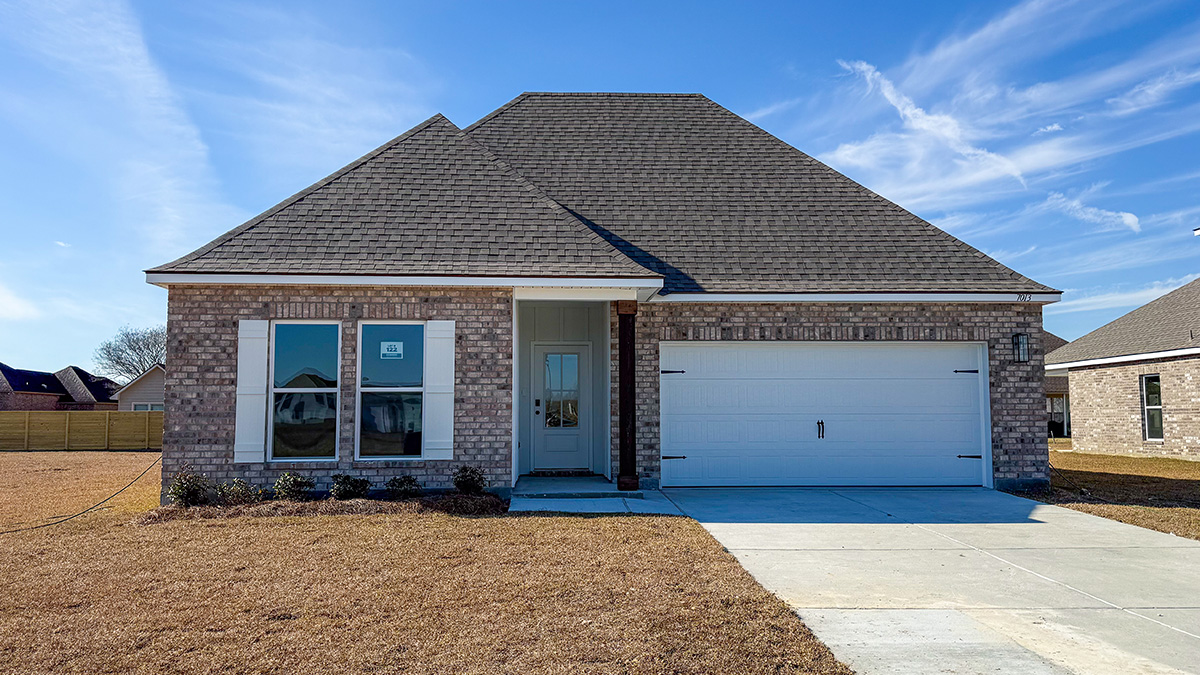 single-story home with tan brick and white front door and shutters with two-car garage