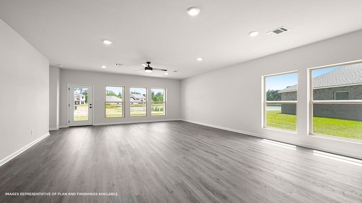 open-concept living space with dual windows on side and rear with patio access