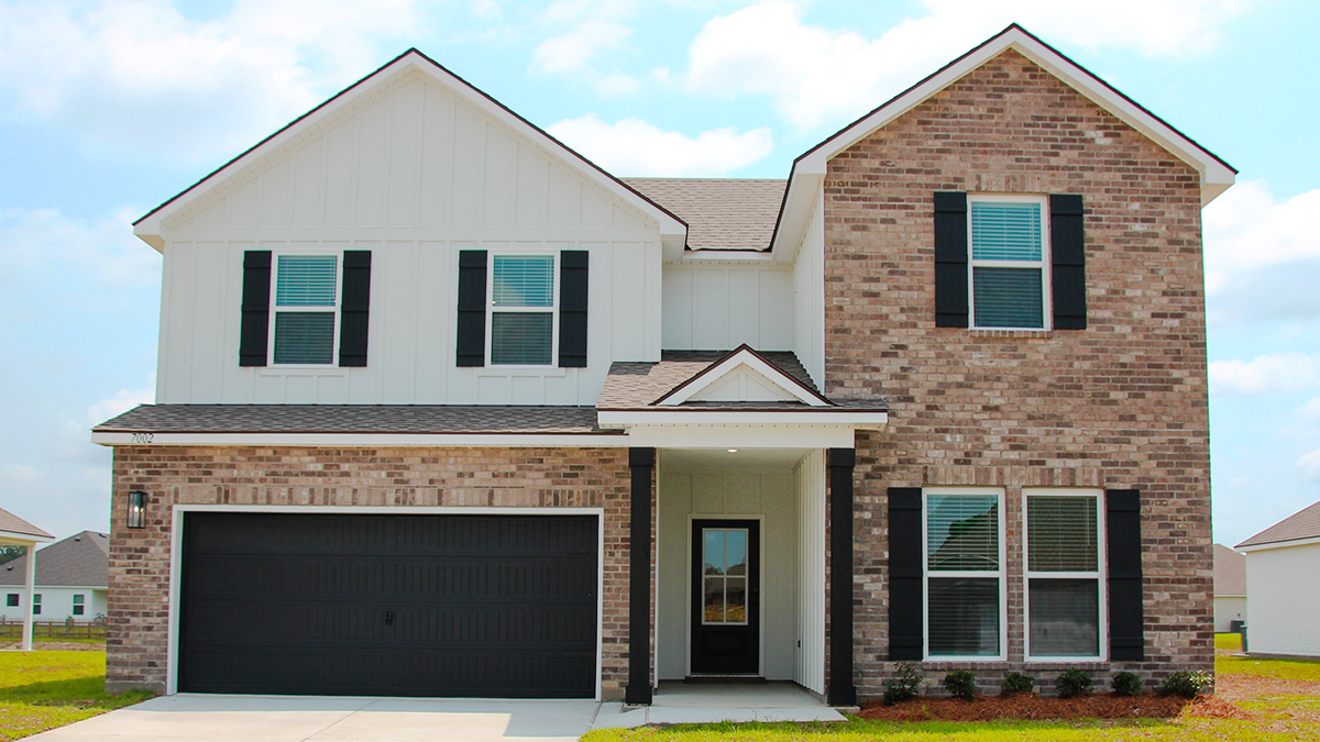 Two-story home with white hardie vinyl and brown brick. Black glass front door with black shutters and white trim.