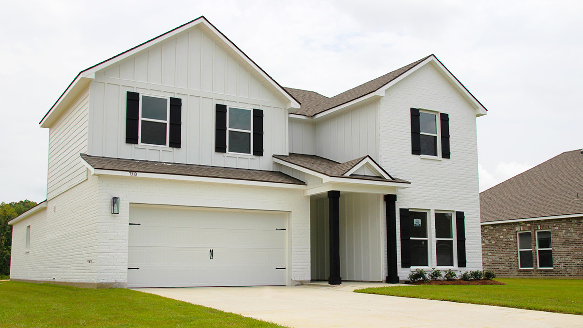 Two-story home with white hardie vinyl and white brick. Black glass front door with black shutters and white two car garage.