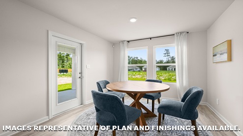 Open-concept dining room with dual windows facing backyard