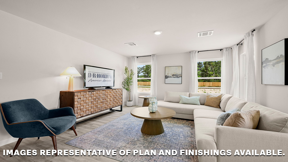 Open-concept living room with dual windows facing backyard