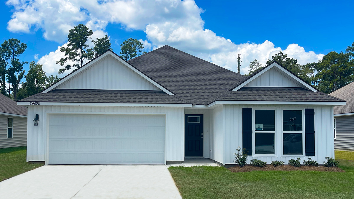 Single-story home with white brick. Black glass front door with black shutters and white trim.