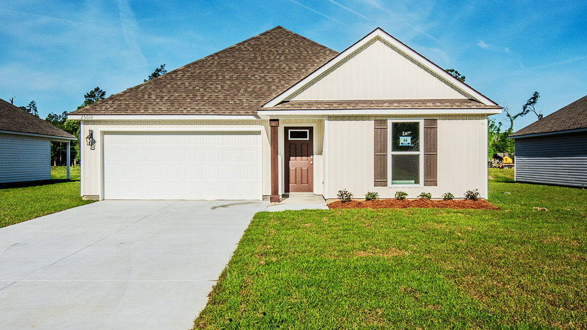 single-story home with tan vinyl siding and brown front door and shutters with porch and two-car garage