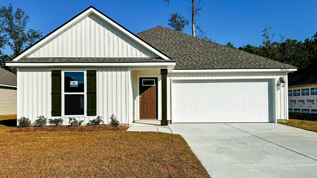 single-story home with white vinyl and brown front door and shutters with two-car garage