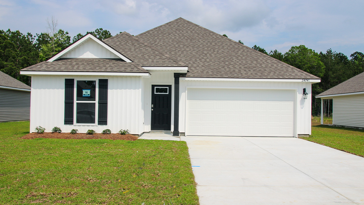 single-story home with white vinyl siding and black front door and shutters with two-car garage