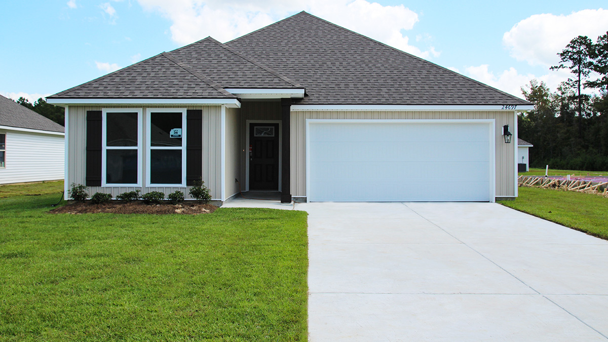 Single-story home with tan vinyl. Brown glass front door with brown shutters and white trim.