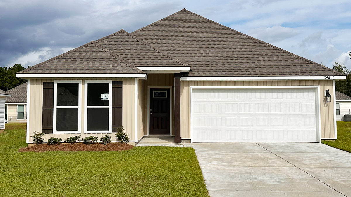 Single-story home with cream vinyl. Black glass front door with black shutters and white trim.