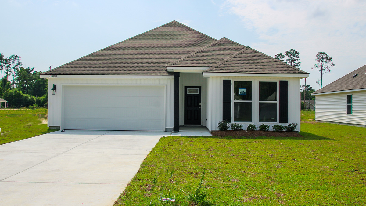 single-story home with white vinyl siding and black front door and shutters with two-car garage