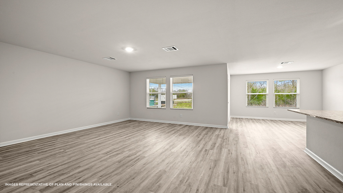 Open-concept living, dining room and kitchen Dark grey kitchen cabinets and island with stainless steel appliances and foyer access