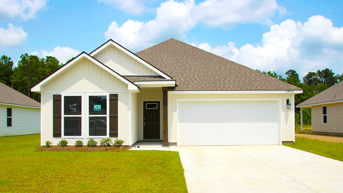 Single-story home with cream Vinyl with brown shutters and black door. White two car garage.