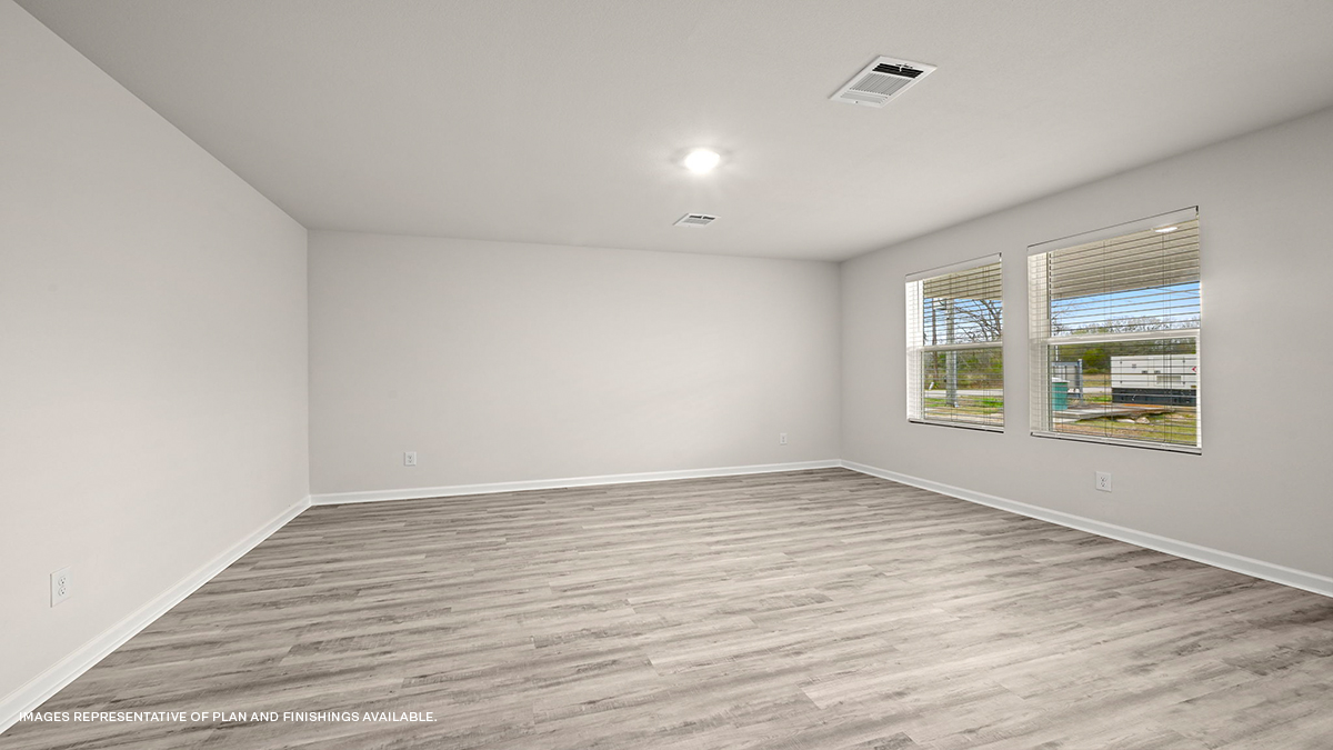 Spacious living room in the rear of home with dual windows facing backyard