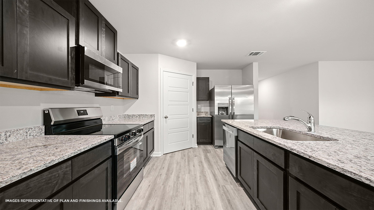 Dark grey kitchen cabinets and island with stainless steel appliances and pantry access
