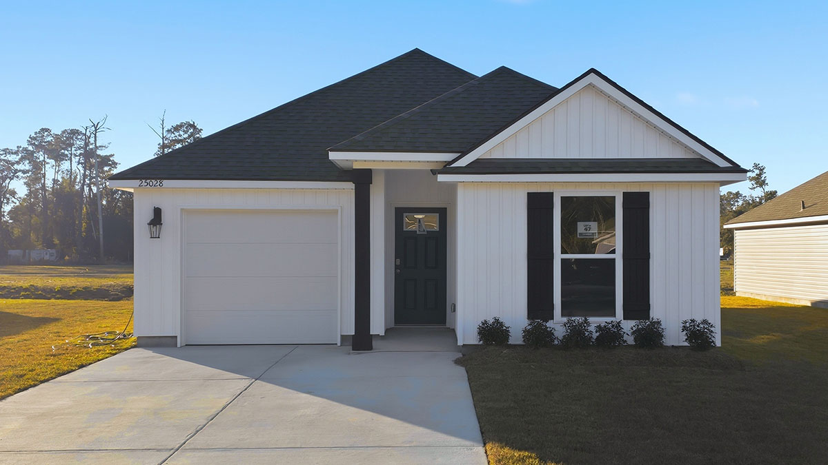 single-story home with white vinyl siding and black front door and shutters with two-car garage