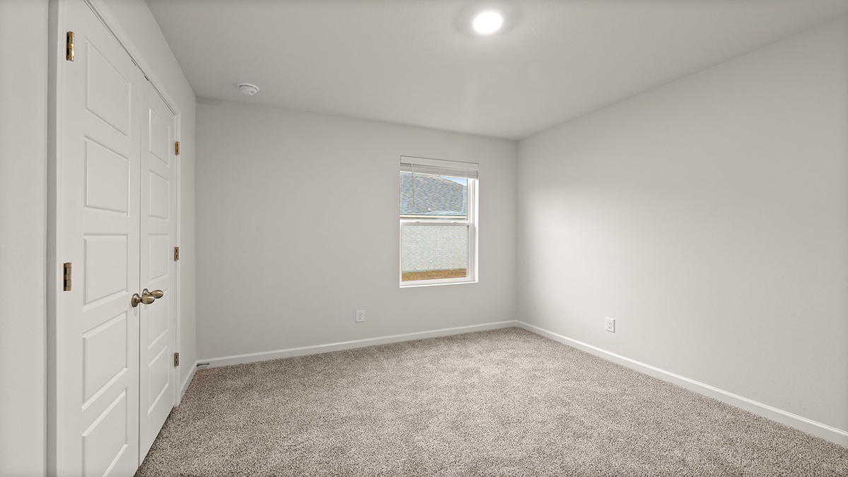 second bedroom with single window and room for a queen bed