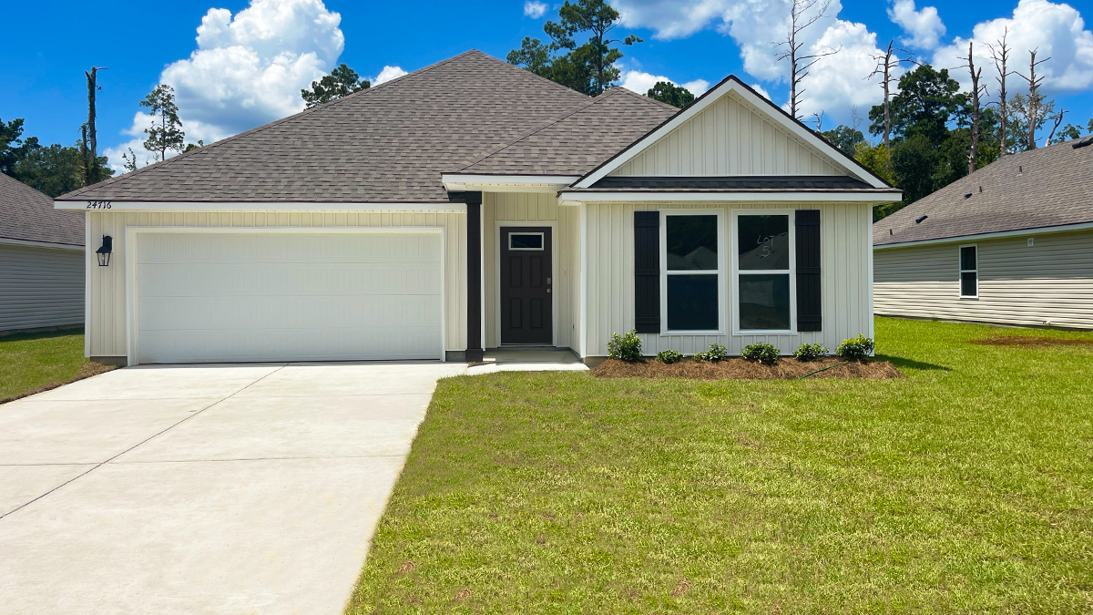 Single-story home with white brick. Black glass front door with black shutters and white trim.
