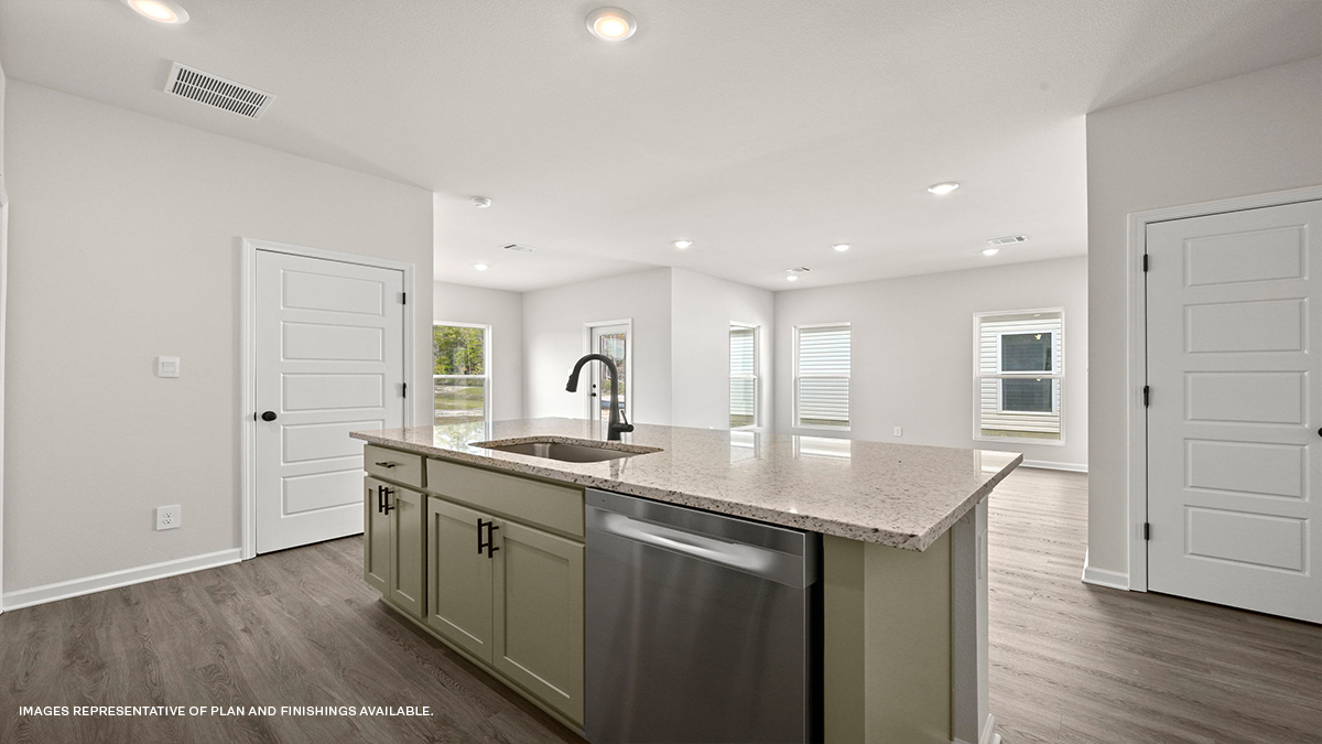 Tan kitchen island and dishwasher with living space in the background