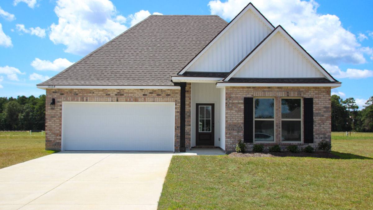 Single-story home with brown brick. Black glass front door with black shutters and white trim.
