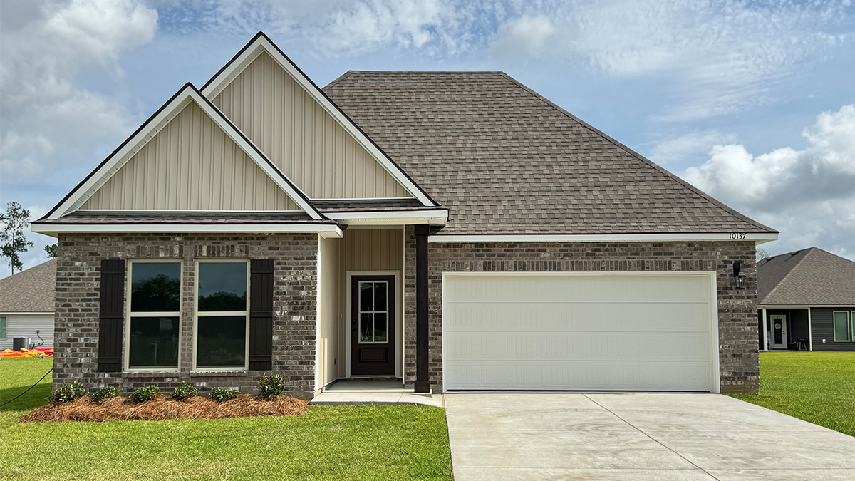 Single-story home with brown brick and tan vinyl. Dark brown glass front door with dark brown shutters and white trim.