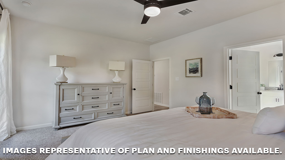 Large primary bedroom with dual windows overlooking the backyard