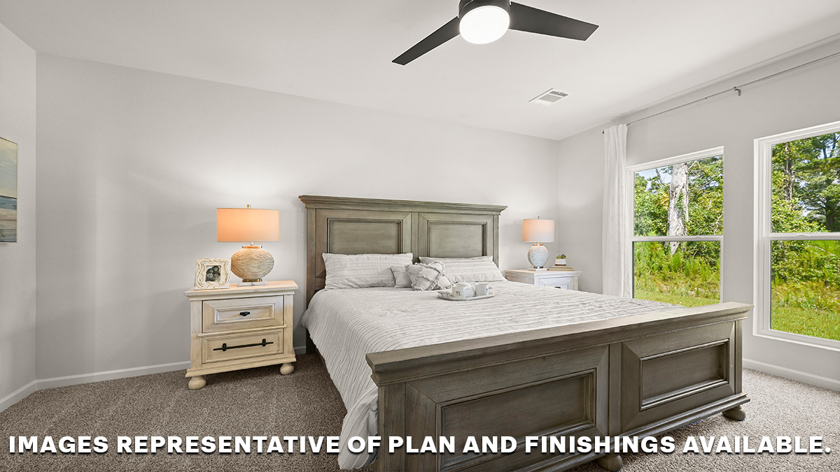 large primary bedroom with dual windows overlooking the backyard